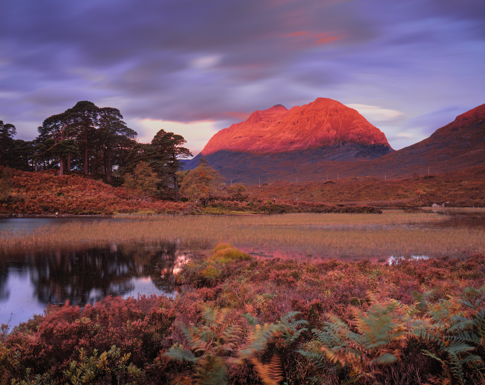 Liathach lit up red across Loch Clair at dawn