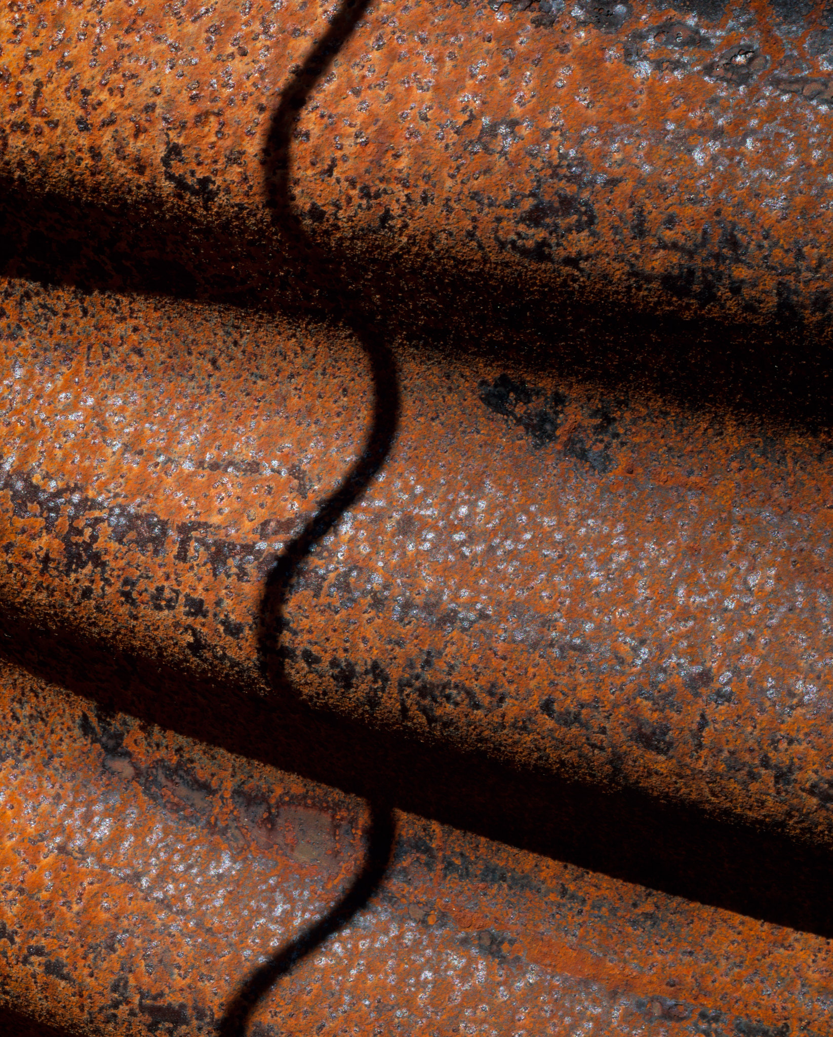 Corrugated iron with a shadow from a wire